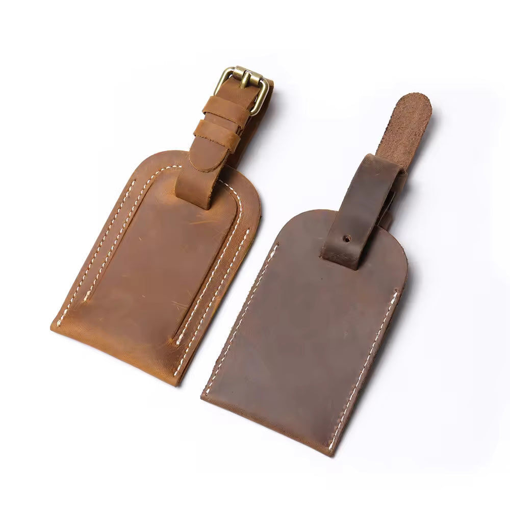 Handcrafted full grain leather luggage tag in brown, featuring white stitching and an adjustable strap with a brass buckle for secure attachment to luggage