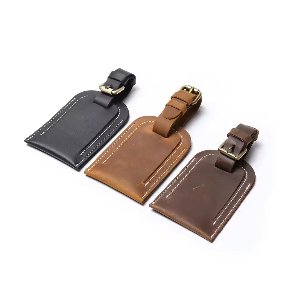 Handcrafted full grain leather luggage tag in brown, featuring white stitching and an adjustable strap with a brass buckle for secure attachment to luggage